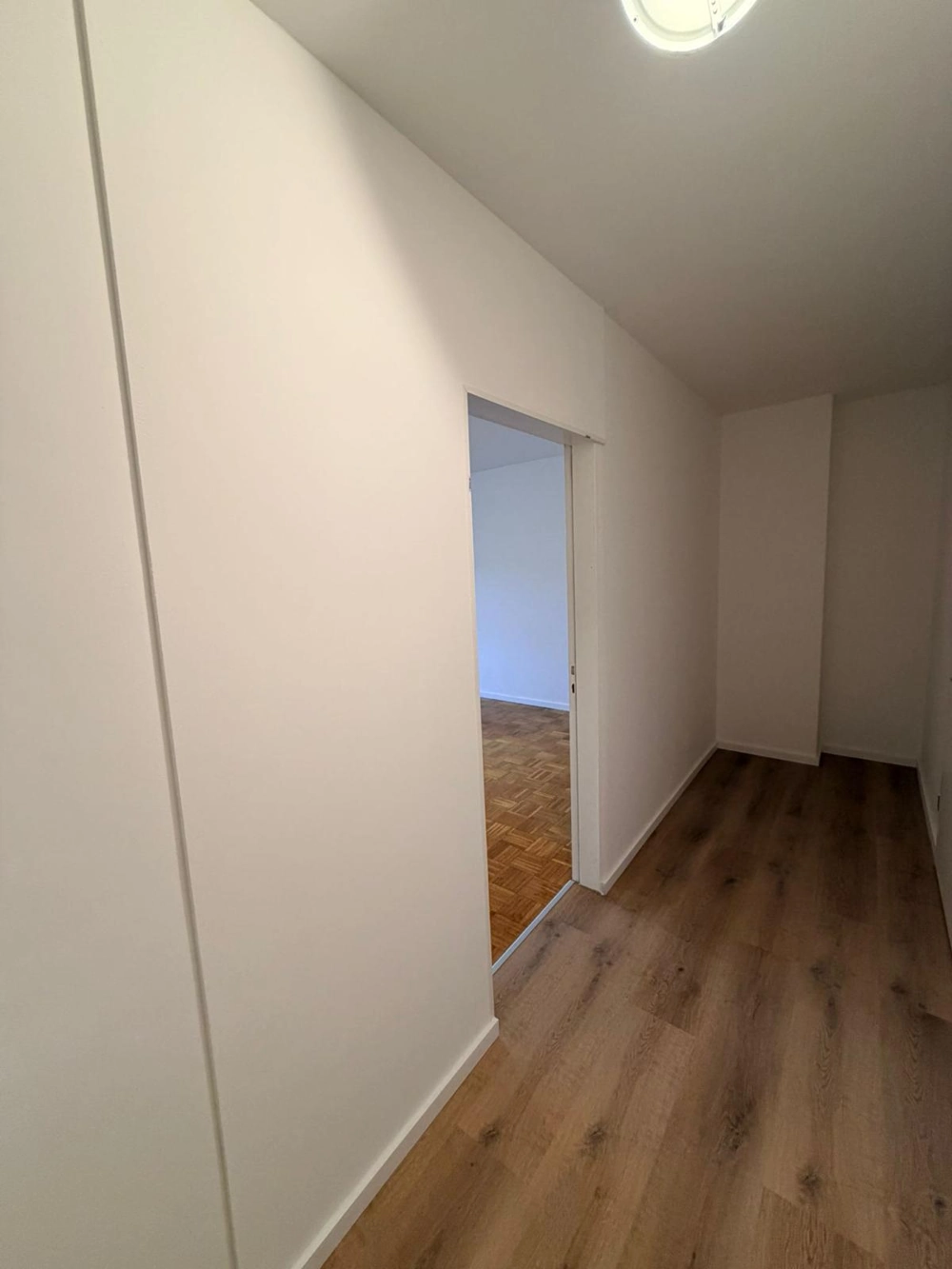 Heller Flur mit neu verlegtem Laminatboden und glatten weiß gestrichenen Wänden Laminat verlegen