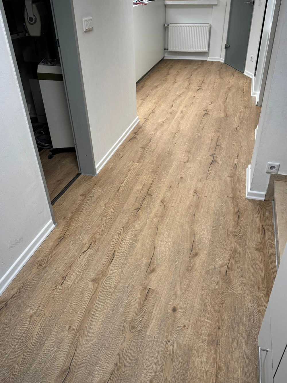 Frisch verlegter Laminatboden in heller Holzoptik im Hausflur, professionelles Laminat verlegen