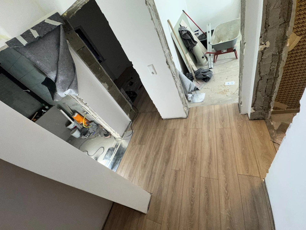 Flur mit frisch verlegtem Laminatboden, Werkzeug und Baumaterialien beim Laminat verlegen