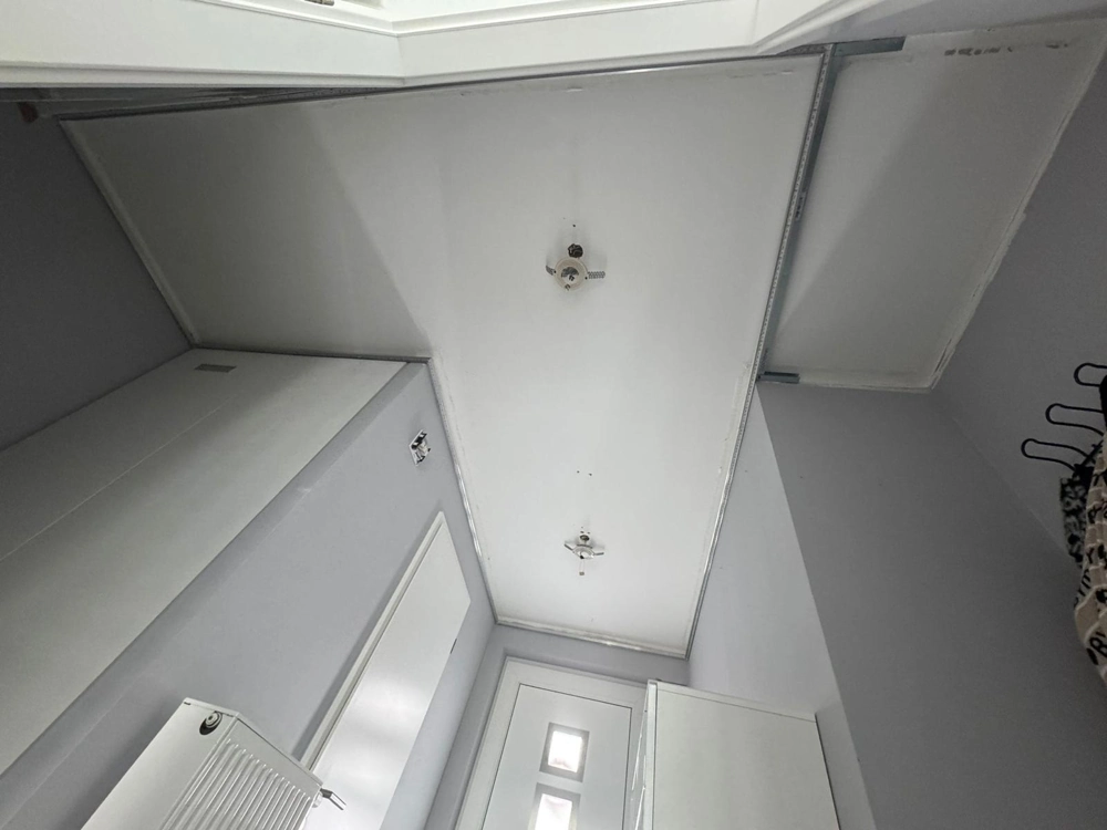 Vorbereitete Rohdecke in Flur mit Metallprofilen für Decke abhängen und Lampenanschlüssen