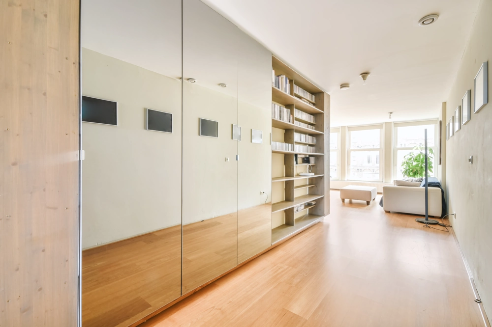 Heller Wohnbereich mit Laminatboden, Einbauregal und Spiegel-Einbauschrank nach Laminat verlegen
