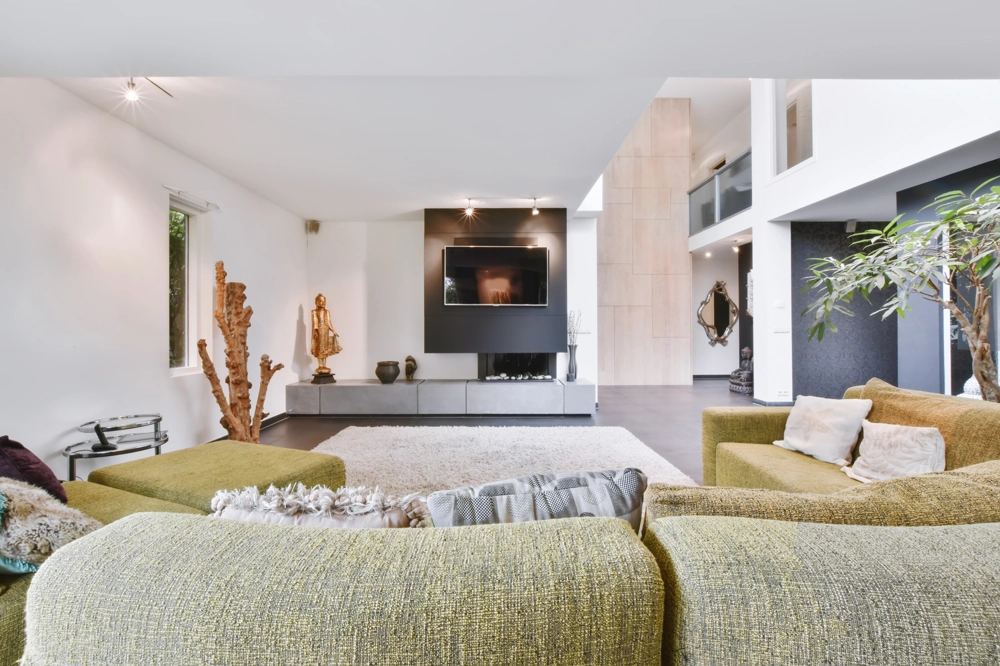 Modern gestaltetes Wohnzimmer mit grünem Sofa, TV-Möbel und offener Raumgestaltung
