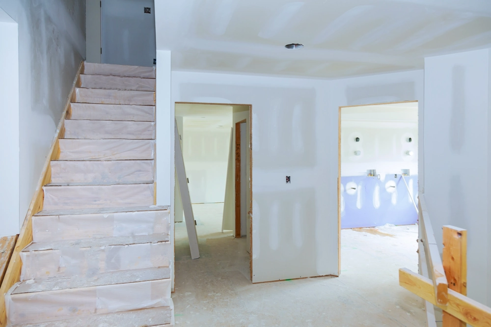 Unfertiger Innenausbau mit Treppe und neu errichteten Trockenbauwänden