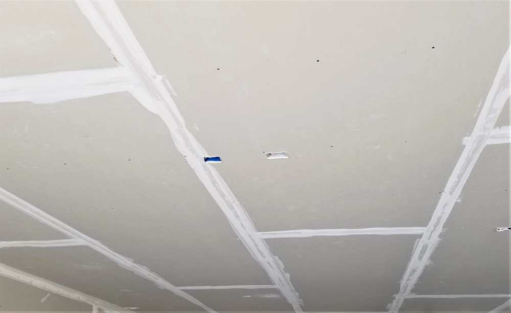 Abgehängte Decke mit verspachtelten Fugen und sichtbarem Trägerrost im Trockenbau