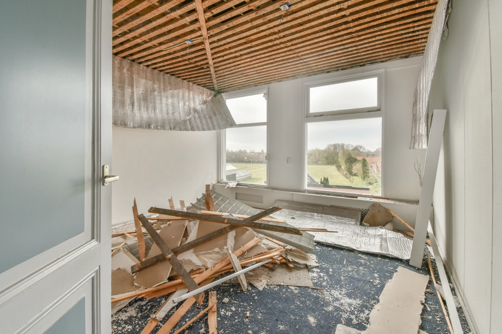 Aufgerissener Innenraum mit abgebrochenen Wänden und Decke, Schutt auf Boden – Abbrucharbeiten