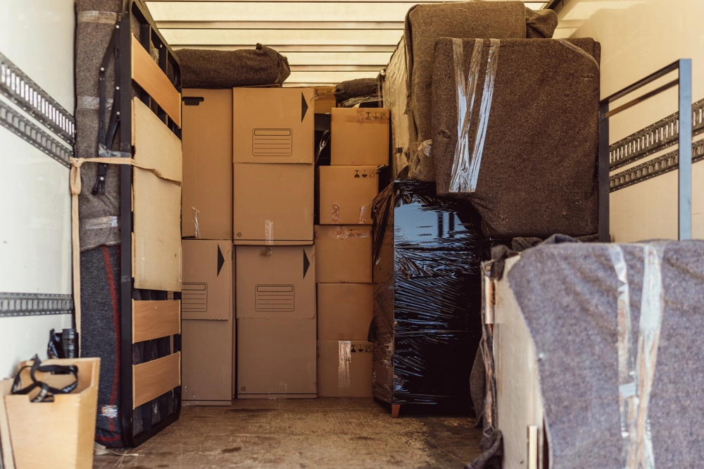 Voll beladener Umzugs-Lkw mit Kartons und schutzverpackten Möbeln bereit für Umzüge
